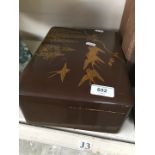 A lacquered box depicting birds on top.