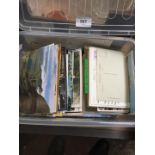 A plastic crate of postcards