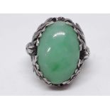 A white metal ring set with a jadeite jade cabochon approx. 19mm x 13mm x 5mm, band unmarked,