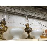 Two brass oil lamps and a pressed glass oil lamp