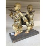A figurine depicting two Chinese boys carrying bucket