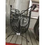 A wrought iron magazine rack with handle
