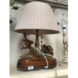 Table lamp featuring ceramic bird figurine on wooden base
