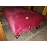 A large Cerise upholstered footstool