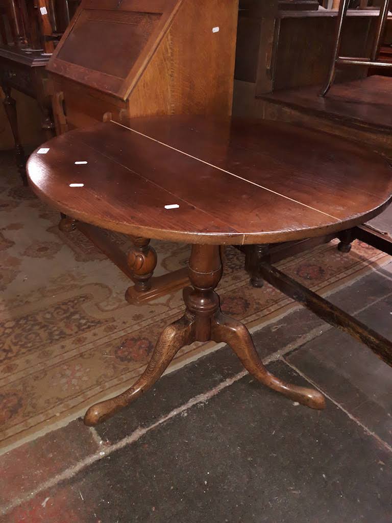 An oak flip top tripod table
