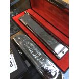 A Hohner Chrometta harmonica and a Larry Adler Professional 16 harmonica
