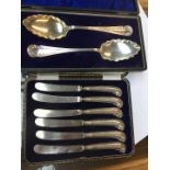 A case containing six silver handled knives and a case with a pair of EPNS serving spoons