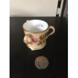A miniature three handled Royal Worcester cup with floral decoration