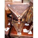 A triangular drop leaf table with carved top and turned legs