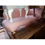 A pink upholstered small chaise