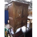 An oak cabinet with geometric panels and carved reliefs