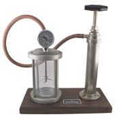 AN OMEGA WATER RESISTANCE PRESSURE TESTING TOOL CIRCA 1960s Metal casing with glass chamber, pump