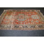 Rust ground rug having brown and green decoration with end tassels - 102" x 65.