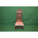 Oak nursing chair the back having decorative carved back splat and pierced carved top rail with