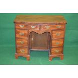 Mahogany bow fronted kneehole desk having two drawers over shaped frieze and single cupboard door