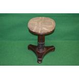 Rosewood revolving piano stool having overstuffed seat supported on carved column leading to