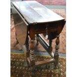 Period oak gateleg dining table having bow ends and two drop leaves over single drawer with hoop