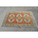 Rust ground rug having blue, yellow and green pattern with end tassels - 79" x 53.