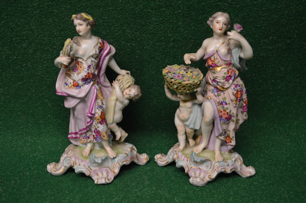 Pair of European porcelain figures of ladies and cherubs, standing on scrolled bases,