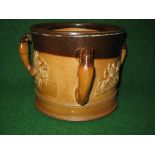 Stoneware three handled loving cup having brown and buff glaze with raised decoration of monkeys