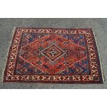 Red ground rug having blue and white decoration with end tassels - 77" x 52"