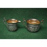 Silver two handled sugar bowl together with a matching cream jug having raised gadrooned decoration,