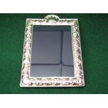 Silver photograph frame having raised decoration of flowers,