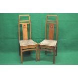 Pair of Arts & Crafts high back rush seated chairs of unusual form with carved roundel to back