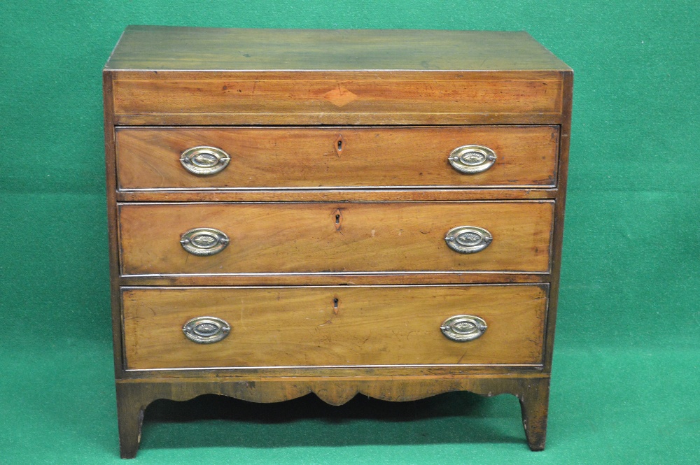 George III mahogany chest of three long graduated drawers with shaped frieze,