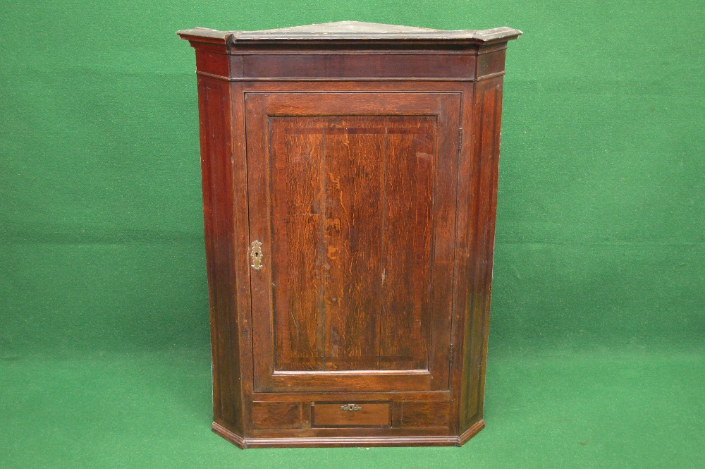 Georgian oak wall hanging corner cabinet having moulded cornice over single panelled door opening