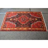 Red ground rug having yellow, green,