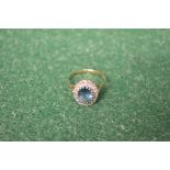 9ct gold ladies ring set with central blue stone surrounded by small diamond chips
