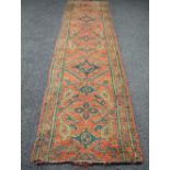 Red ground carpet runner having green and blue decoration - 153" x 36"