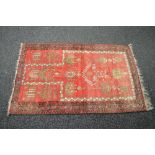 Red ground rug having black, white and beige decoration with end tassels - 58" x 37.