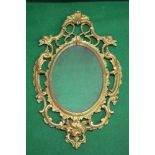 19th century gilt framed wall mirror having pierced scrolled frame surmounting oval mirrored glass