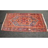 Red ground rug having blue and green pattern with end tassels - 82" x 43"