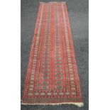 Red ground carpet runner having cream and black pattern with end tassels - 124" x 33.
