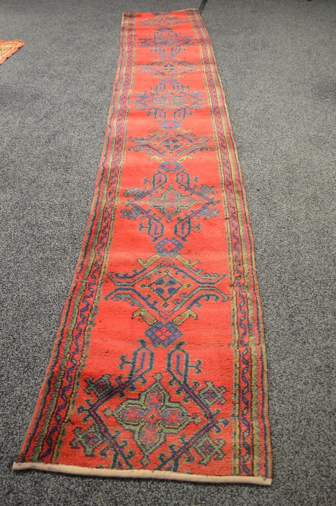 Red ground carpet runner having blue, green and gold decoration - 171" x 27.