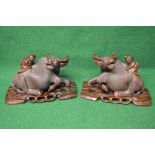 Pair of carved wooden water Buffalos with glass eyes and having Oriental figures on backs,