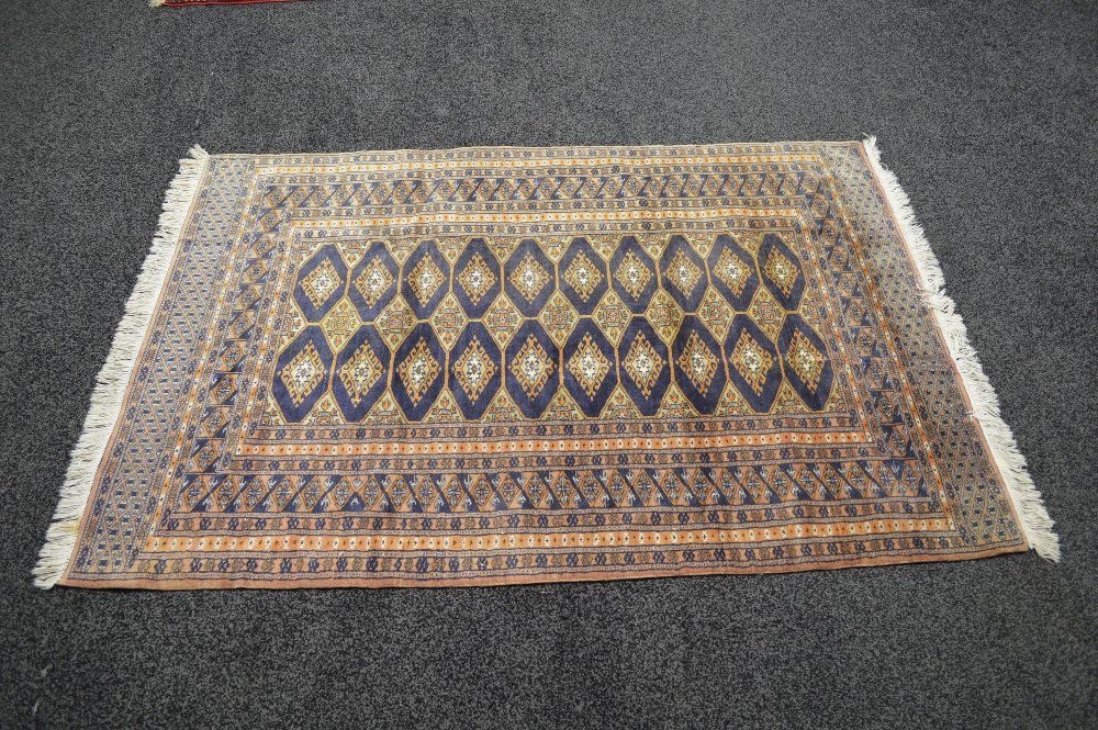 Cream ground rug having gold and black decoration with end tassels - 75" x 49"