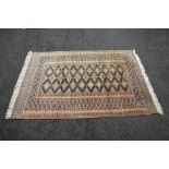 Cream ground rug having gold and black decoration with end tassels - 75" x 49"