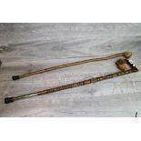 Two walking sticks, one in natural form with Knopp end the other with a carved Wolf head to the