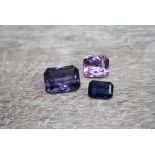 Three loose mixed cut gemstones comprising amethyst, synthetic blue sapphire and synthetic colour