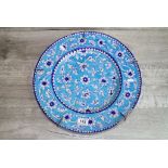Large Iznic style ceramic Charger with Floral decoration on blue ground
