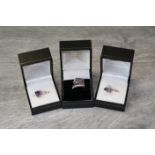 Three silver gem set rings comprising amethyst and white stone ring, the large square mixed cut