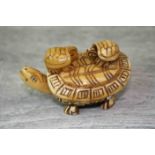 Bone netsuke figure of a turtle with two babies to back