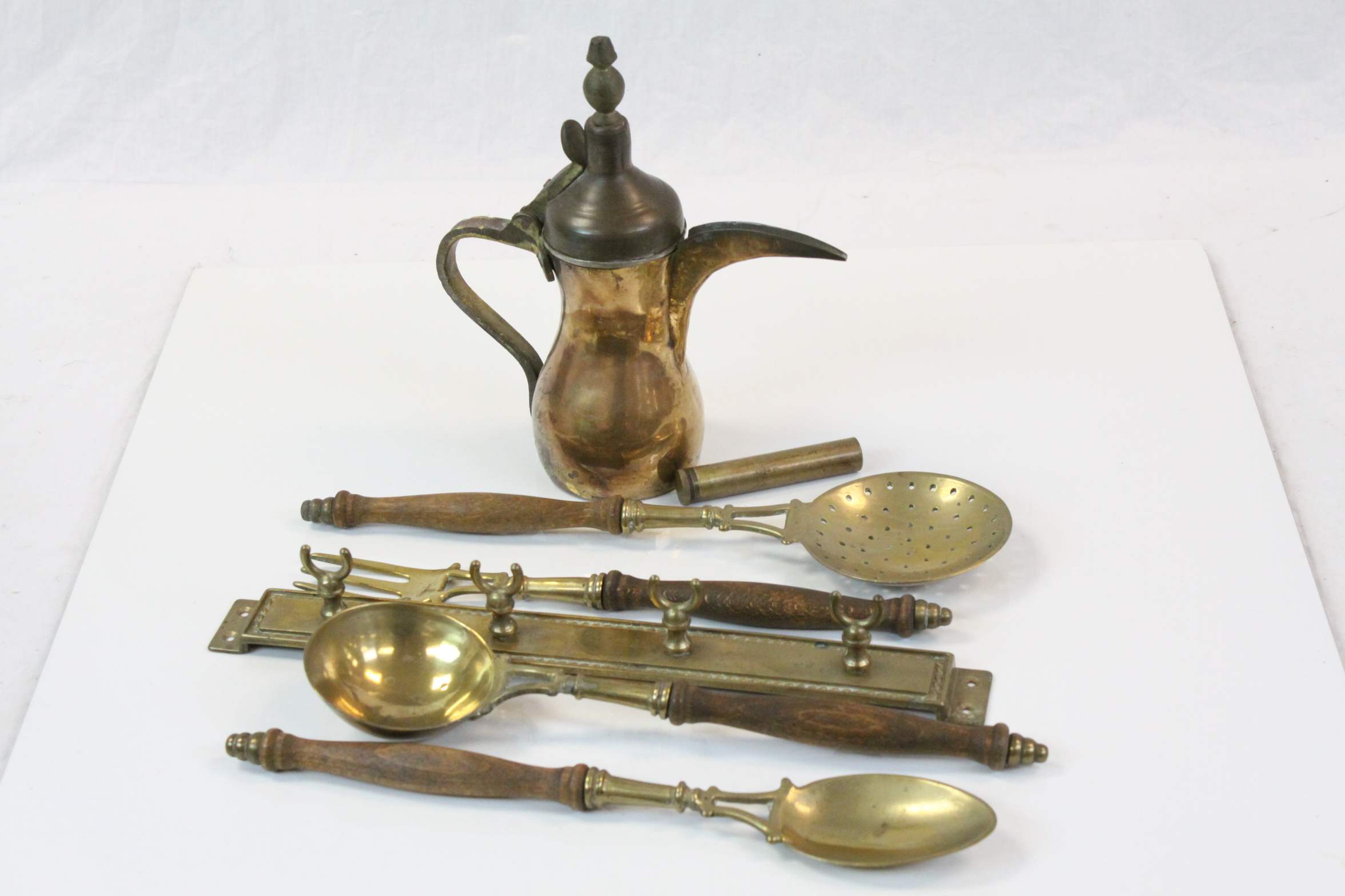 Brass kitchen utensils with wall mount together with a Persian brass hot water/coffee pot