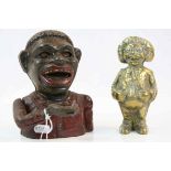 Native African cast iron money box of a jolly man wearing a red jacket, height approximately 15cm