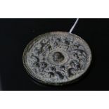 An oriental bronze hand mirror with dragon decoration