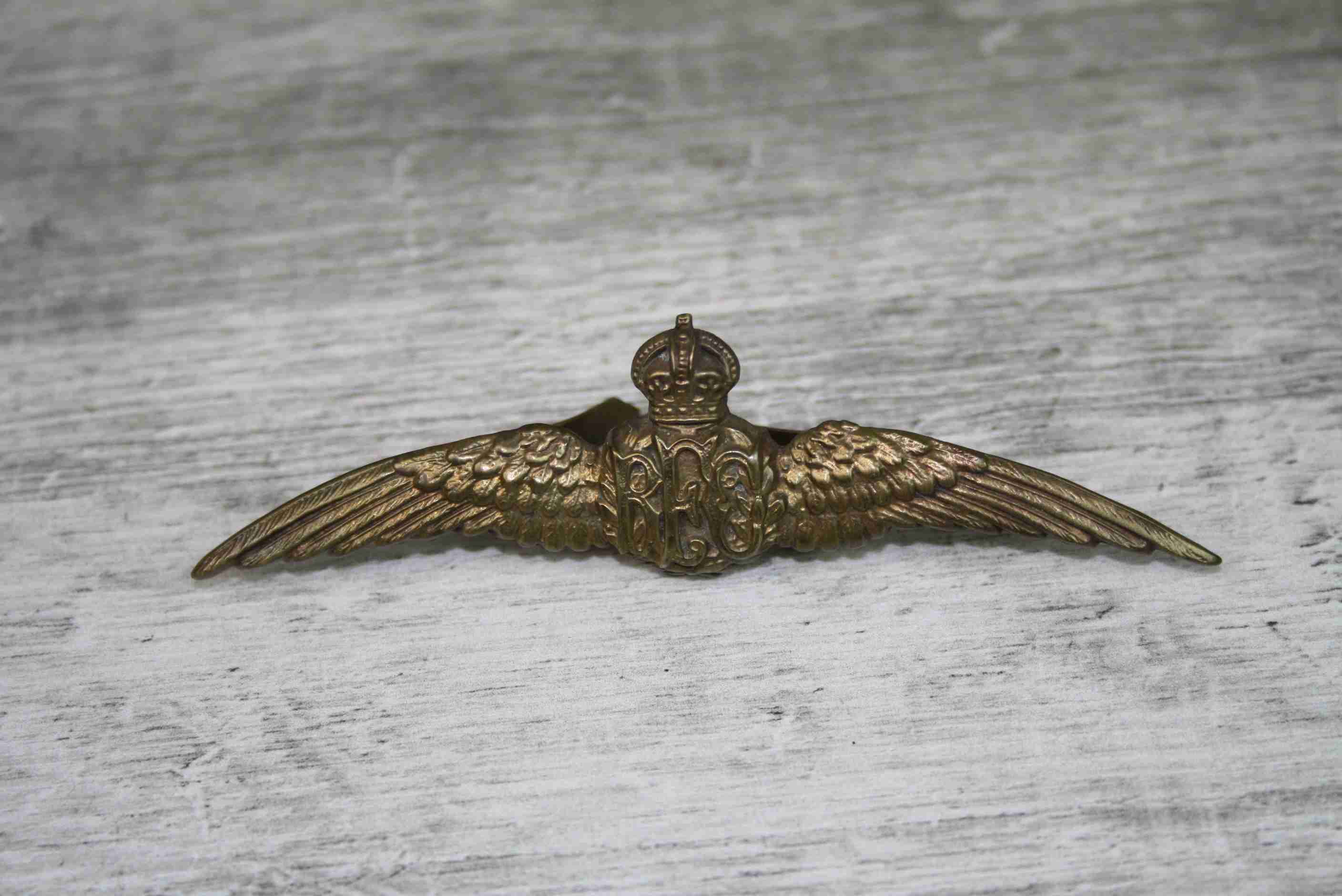 Royal Flying Corp WWI brass wings cap badge with Kings Crown, length approximately 9cm